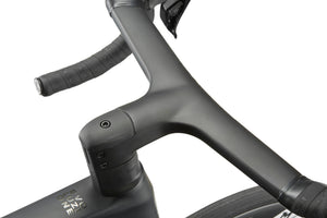 Close-up of a dark gray handlebar and stem on the EVOLUZIONE 1, with textured grips and part of an aerodynamic tire.