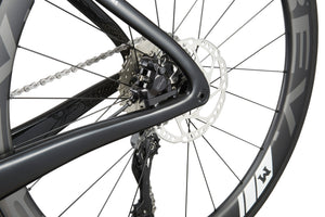 Close-up of EVOLUZIONE 1 racing bikes rear wheel, highlighting the disc brake, chain, and frame in a sleek aerodynamic design.