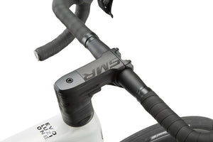 Close-up of EVOLUZIONE 1s carbon bike black handlebars and stem with textured grip on a white frame; brand name is visible.