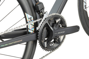 Close-up of a Shimano 105 crankset and chain on a GRAN CORSA carbon road bike, Italian Craftsmanship text in view.