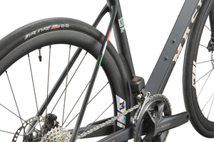 Close-up of GRAN CORSA carbon road bike’s rear wheel, gears, frame branding, and Valkyrie tire label.