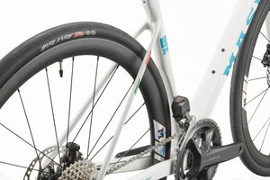 Close-up of the GRAN CORSA carbon road bike frame with rear wheel, gear cassette, chain, and crankset on a white background.