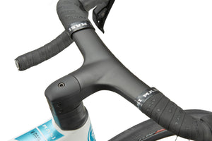 Close-up of black handlebars and stem with wrapped grips on a white GRAN CORSA carbon road bike frame and front wheel.