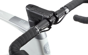 Close-up of EVOLUZIONE 1s handlebars wrapped in black grip tape and a sleek black stem branded Bravia. Partially visible Masi Bikes carbon frame showcases its aerodynamic design with logo and text.